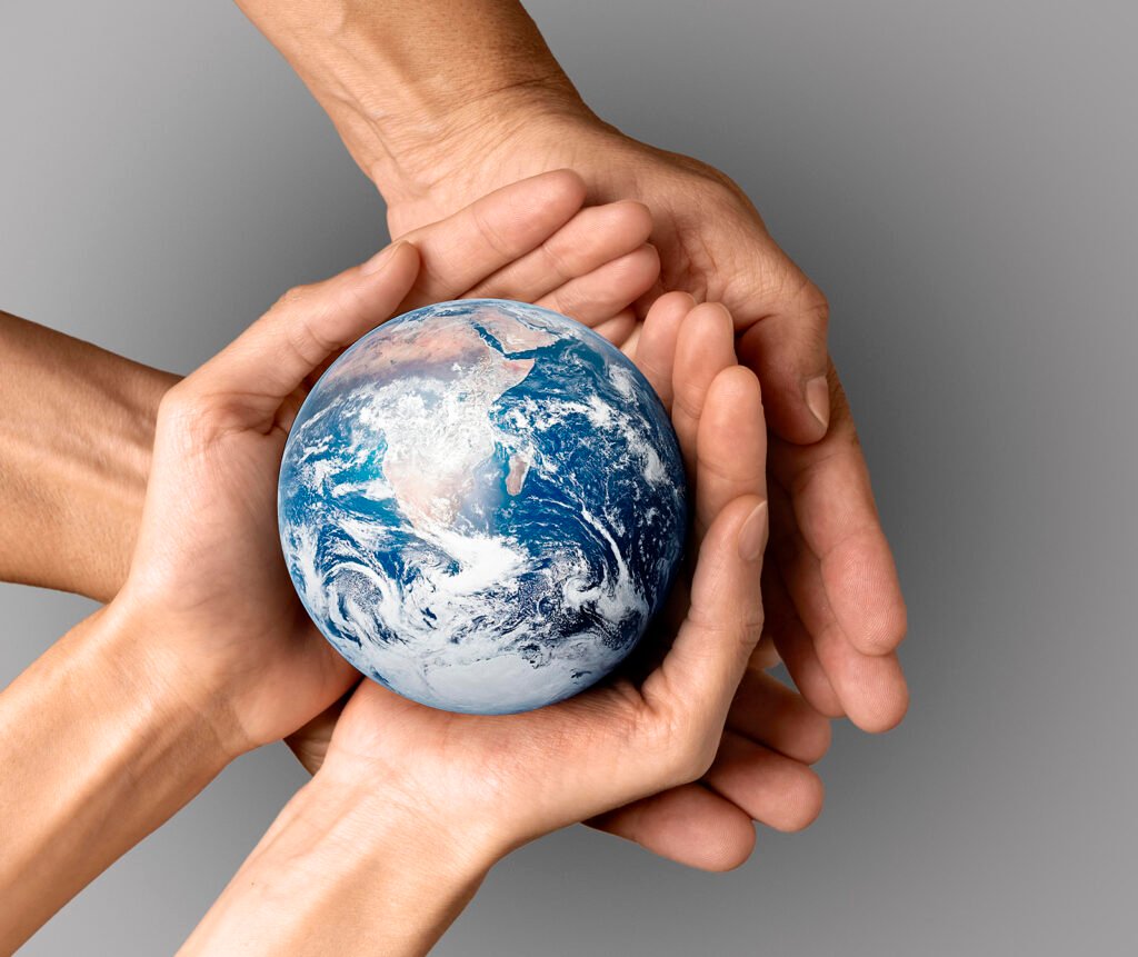 Mãos humanas segurando o planeta Terra, simbolizando a responsabilidade coletiva com os ODS e a sustentabilidade global.