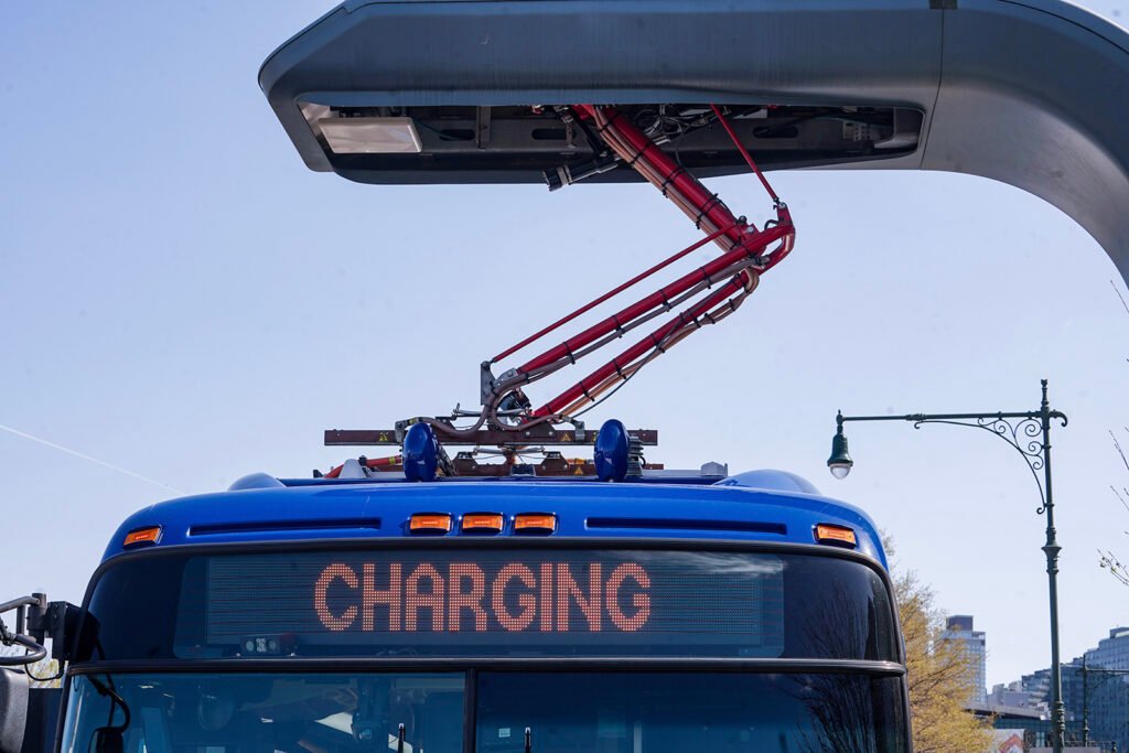 Ônibus elétrico sendo recarregado, símbolo do turismo urbano sustentável aliado à mobilidade limpa nas grandes cidades.