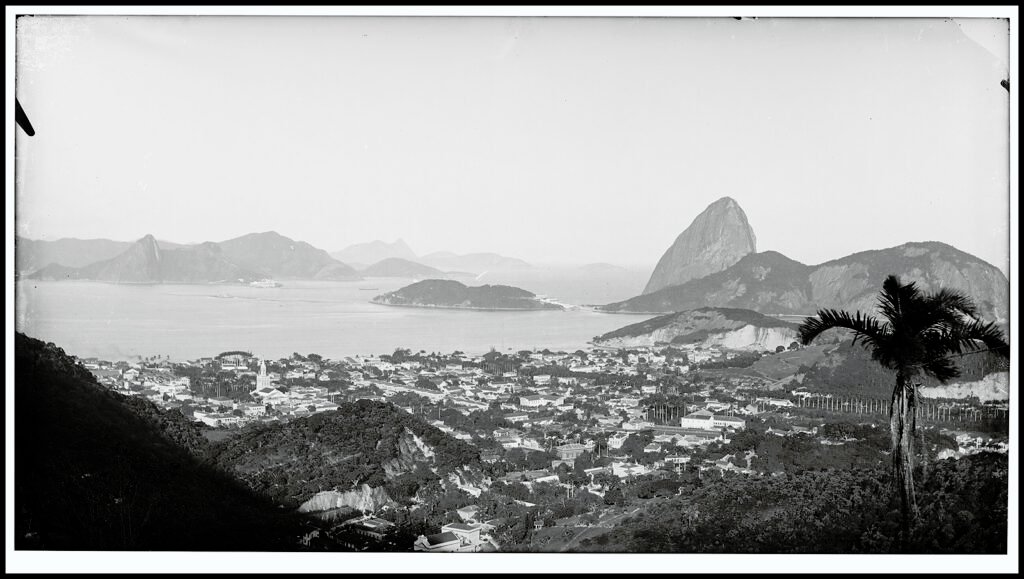 Fotografia histórica em preto e branco da Baía de Guanabara com destaque para o Bairro do Flamengo e o Pão de Açúcar, no Rio de Janeiro.