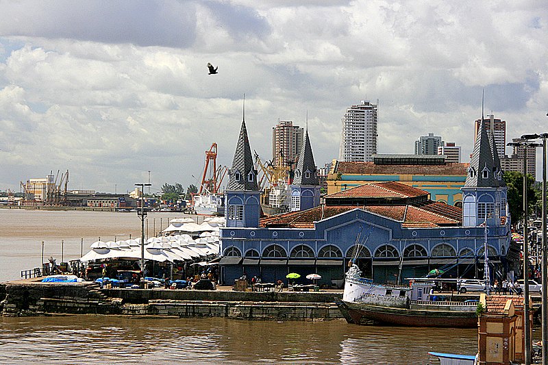 Vista do Mercado Ver-o-Peso em Belém do Pará, com suas torres azuis, barcos atracados e barracas de feira às margens da baía do Guajará